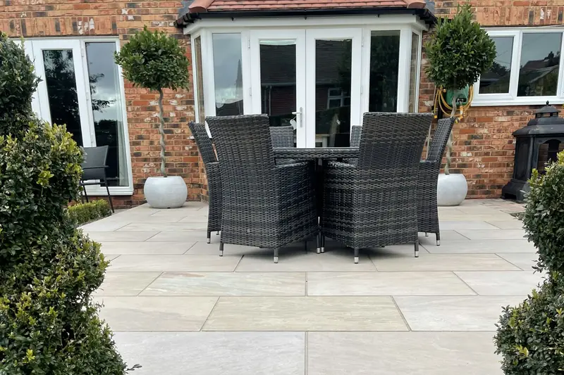 Patio outside a brick house with conservatory